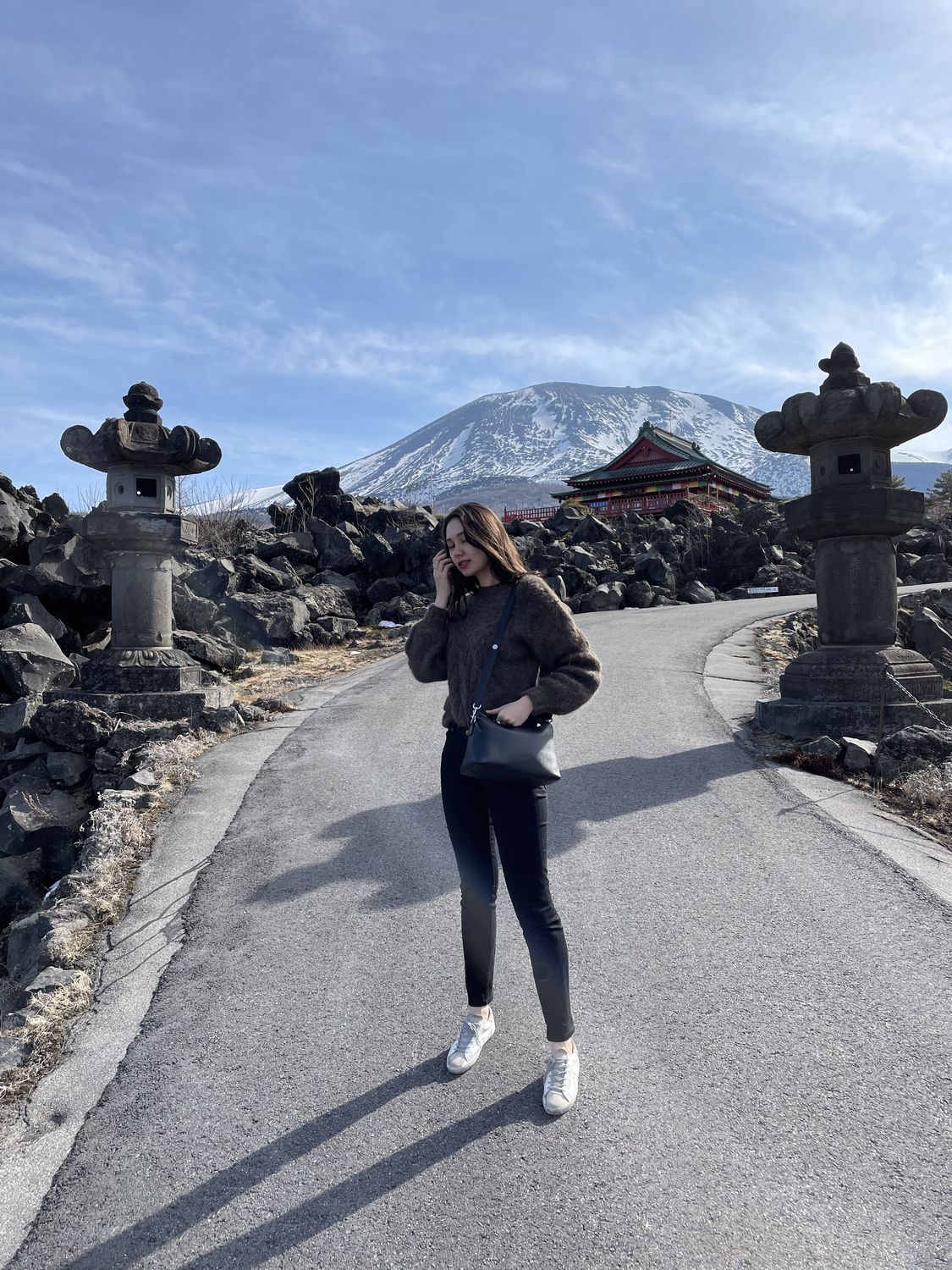 A road through lava fields toward a mountain shrine