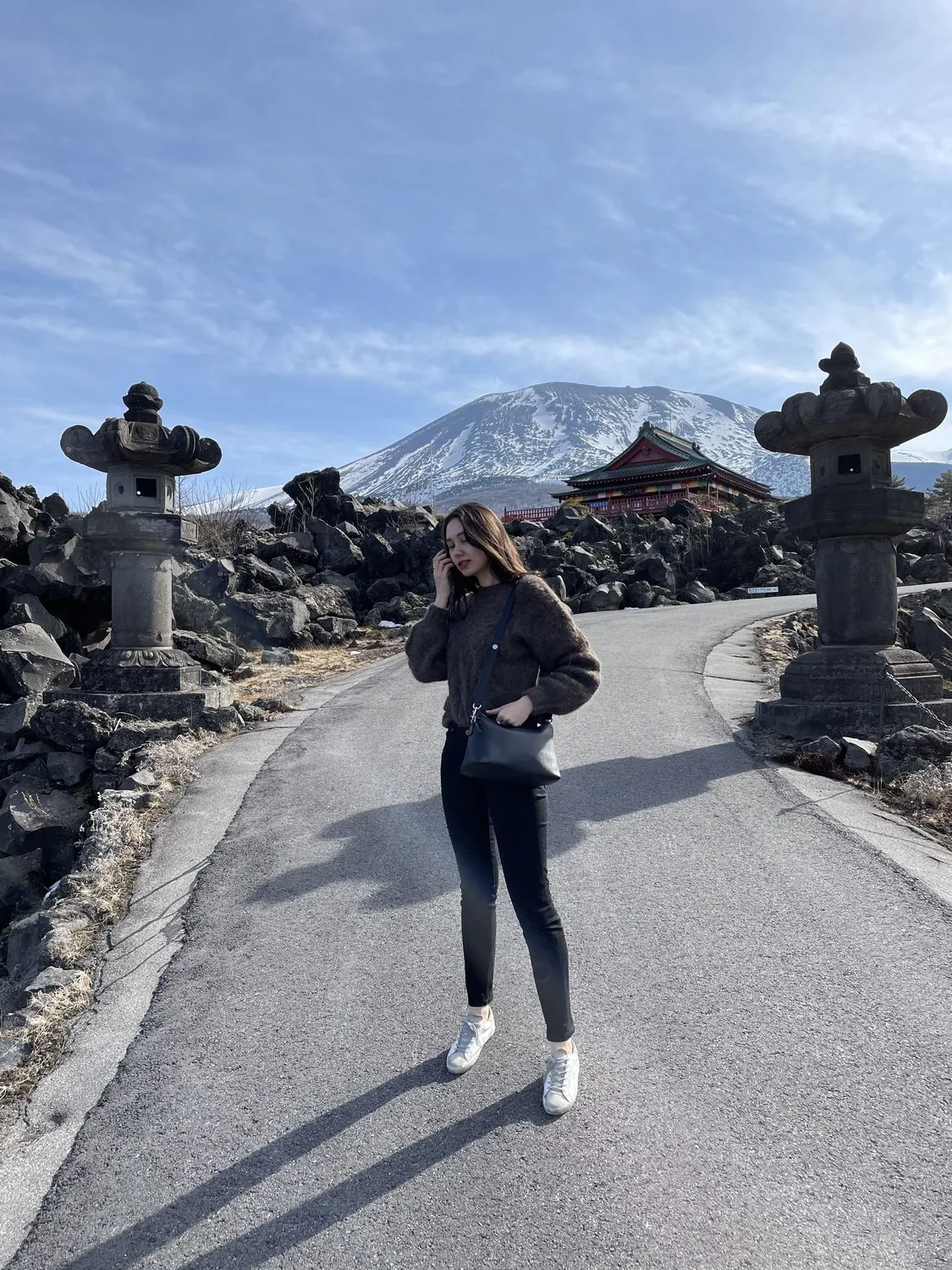 A road through lava fields toward a mountain shrine