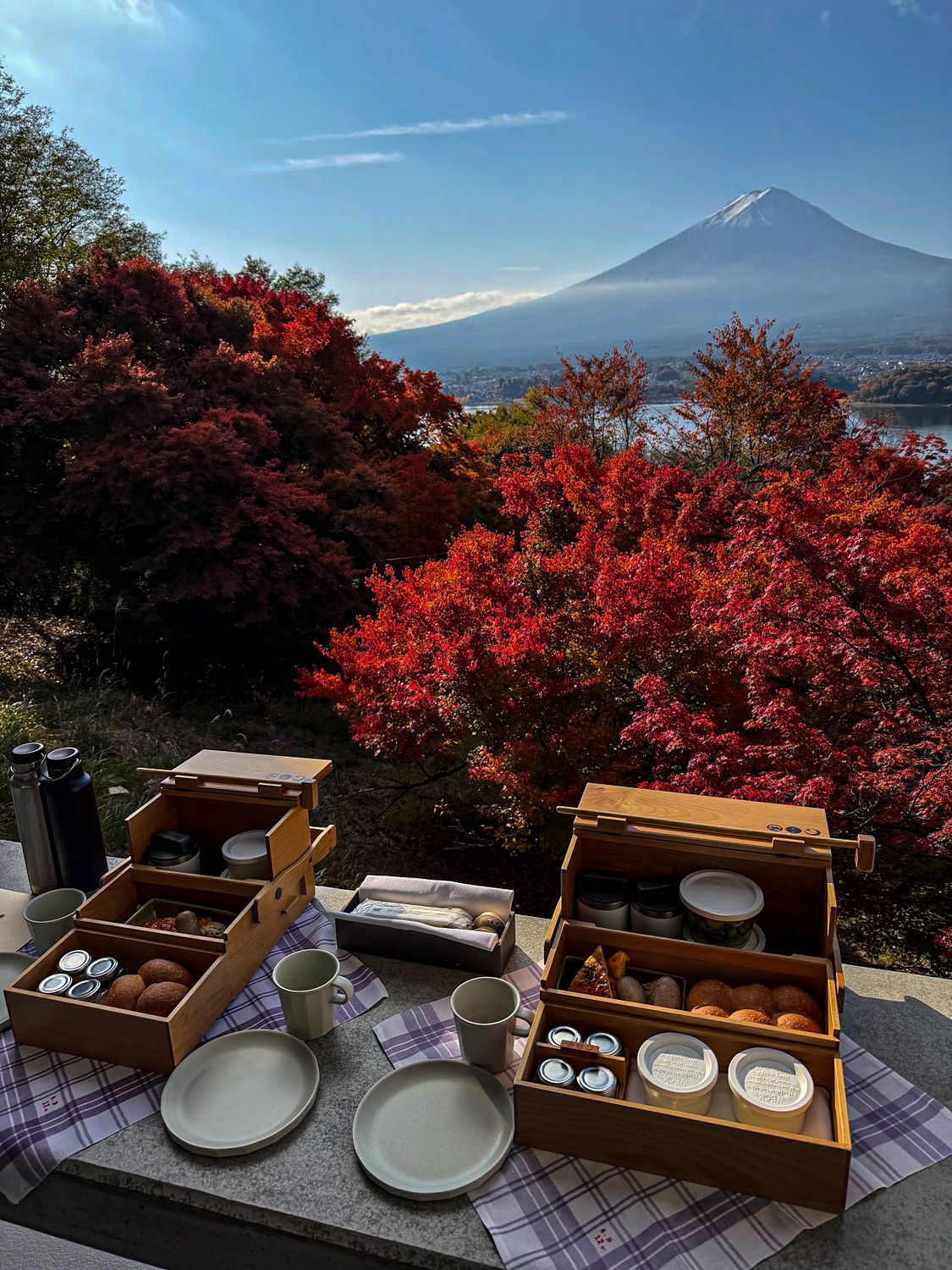 Breakfast laid out on a terrace with Mount Fuji and autumn maples beyond