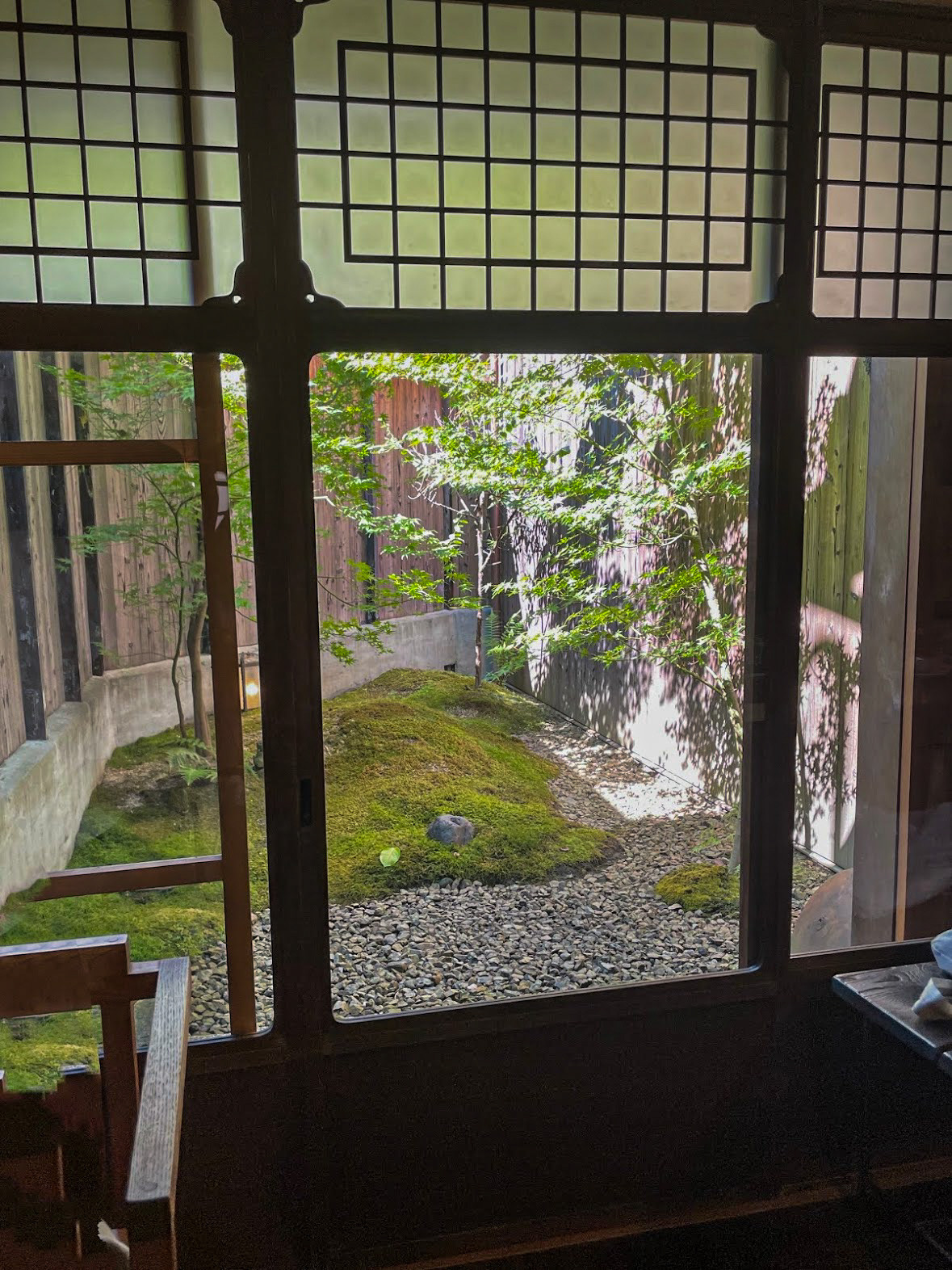 A small garden seen through wooden window frames and shoji panels