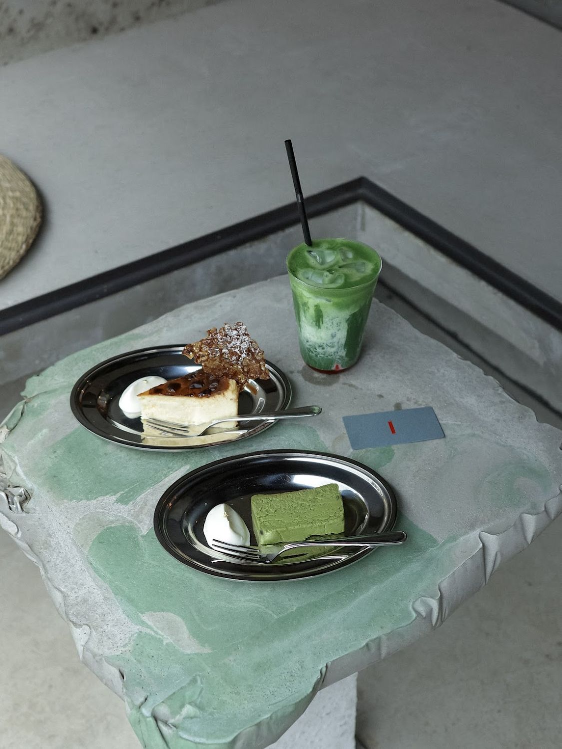 Matcha and a slice of cake on a stone counter