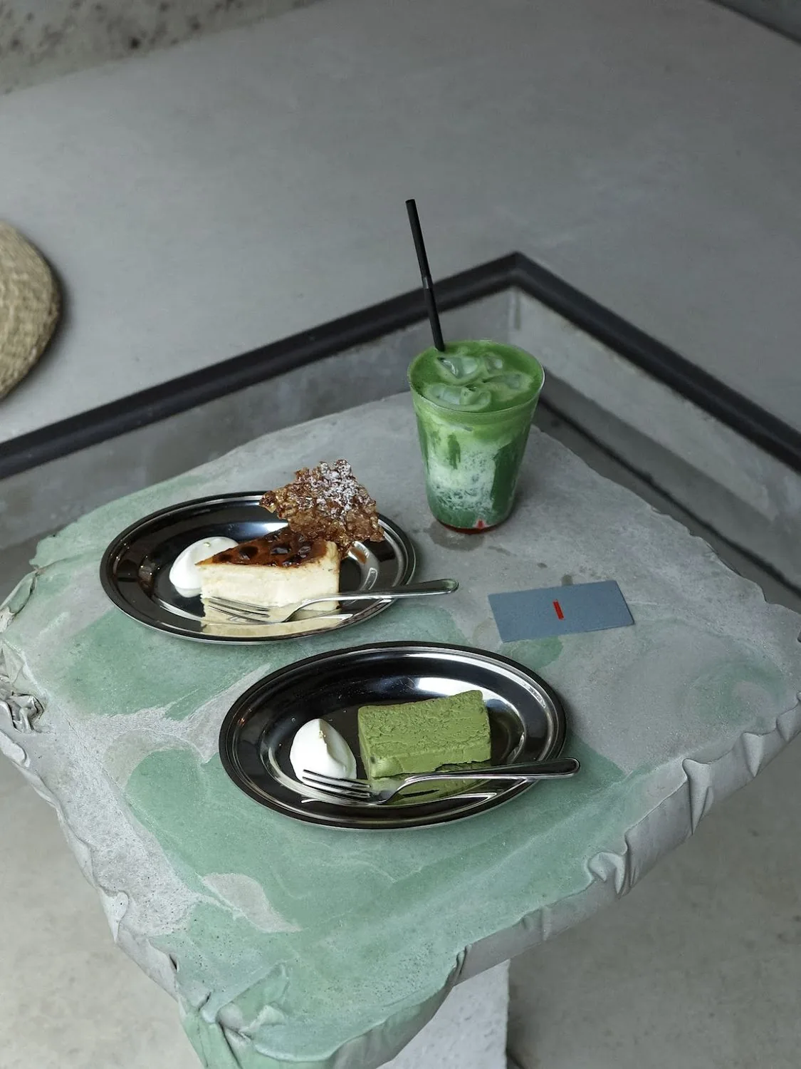 Matcha and a slice of cake on a stone counter