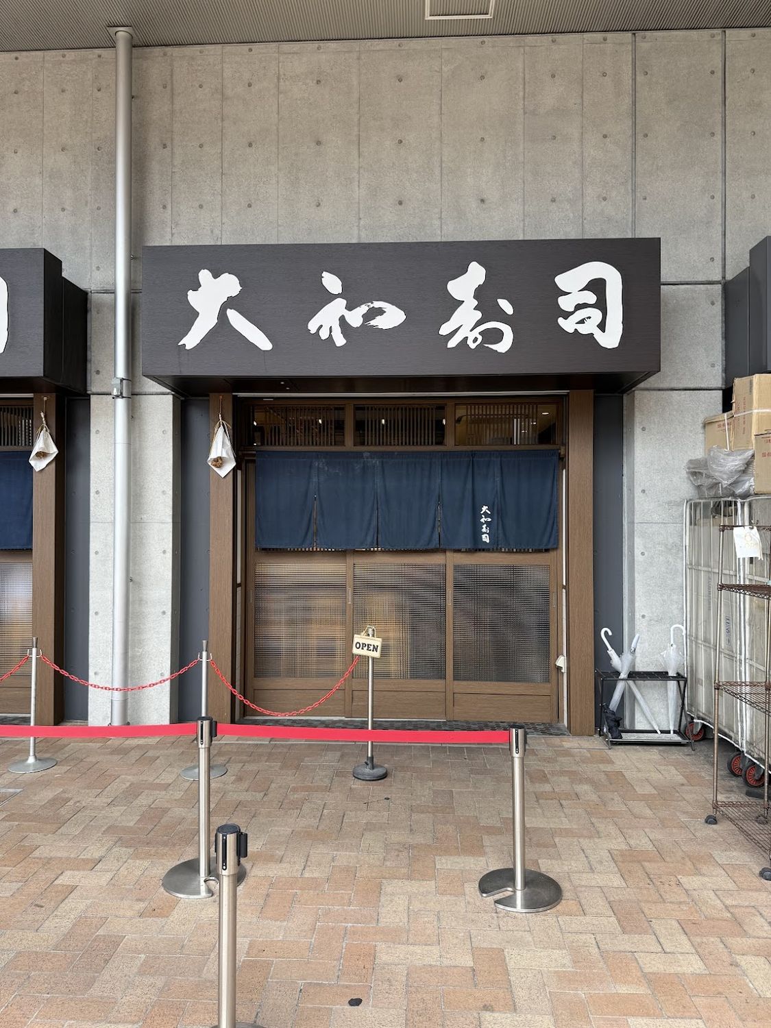 The entrance to a small sushi restaurant behind a noren curtain