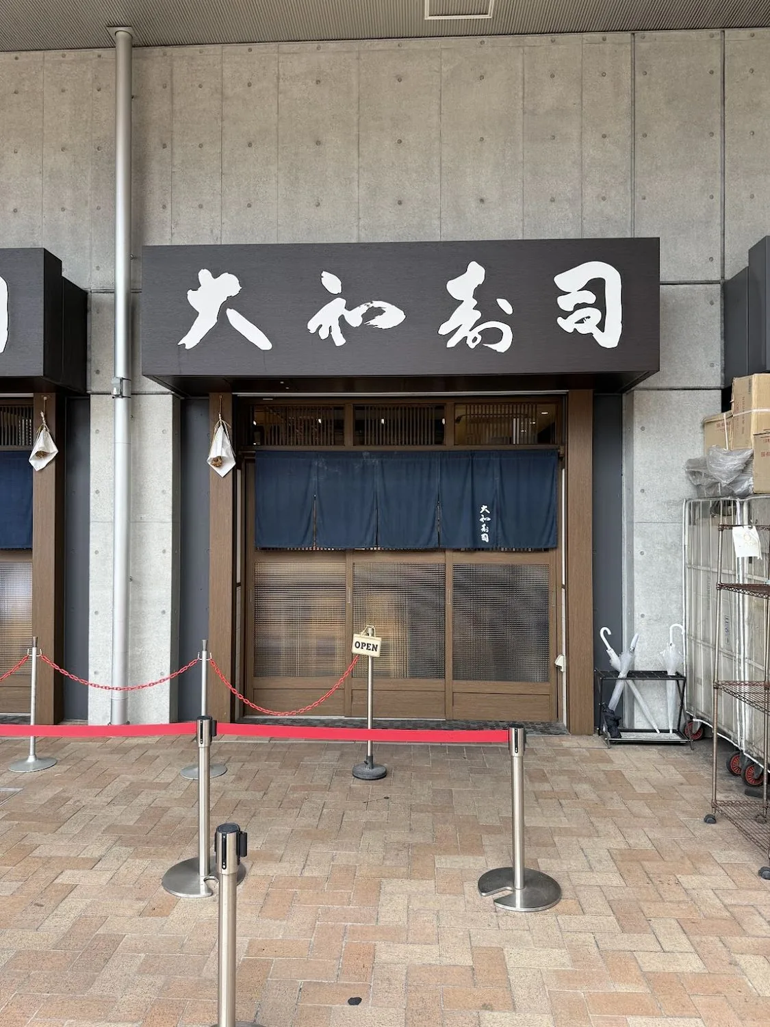 The entrance to a small sushi restaurant behind a noren curtain